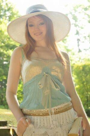 Natural redhead Charlie Edwards removes a sunhat while getting naked in a yard on nudesceleb.com