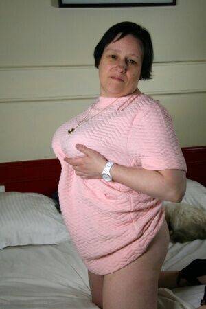 Fat older woman undresses on her bed before toying her pussy on a bed on nudesceleb.com