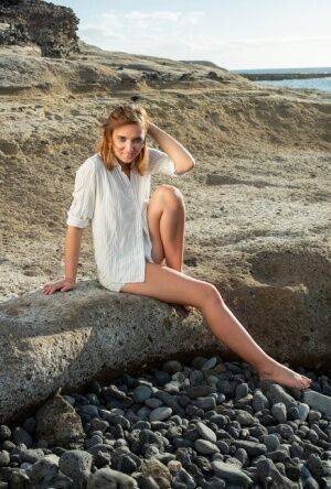 Pretty teen Oxana Chic disrobes for a nude modelling gig on a beach on nudesceleb.com