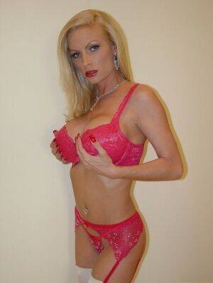 Older blonde babe Diamond Foxxx toys her twat on a bed in white stockings on nudesceleb.com