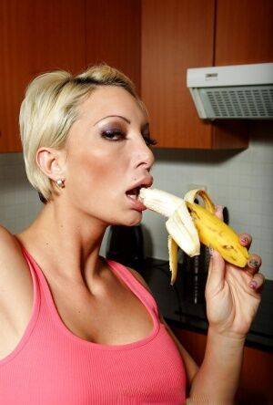 Tight pornstar Pearl Diamond eating a banana and posing naked in a kitchen on nudesceleb.com