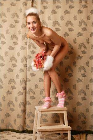 Blonde girl Sweet Lilya wears furry gloves and socks during a nude solo shoot on nudesceleb.com