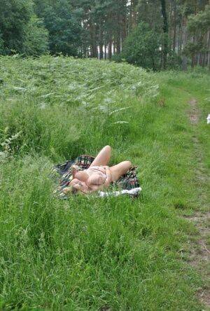 Big titted mature plumper Curvy Claire slides her panties aside in a field on nudesceleb.com