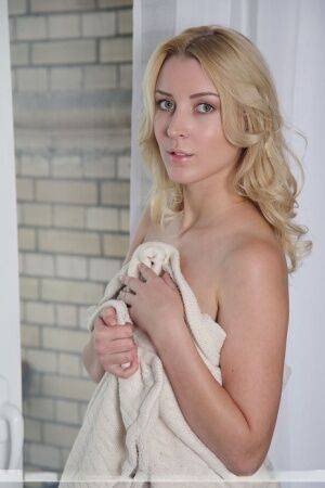 Fair-skinned blonde Amaris removes a bath towel to model butt naked on nudesceleb.com