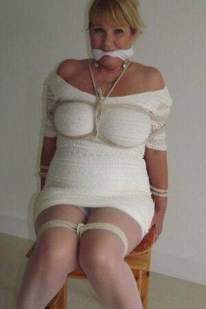 Blonde female is cleaved gagged and tied with rope in a number of dresses on nudesceleb.com