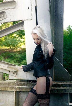 European teen Adelina White takes a pee on trestle bridge in black stockings on nudesceleb.com