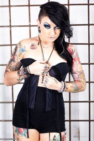 Tattooed girl Draven Star gets naked in heels inside a steel cage on nudesceleb.com