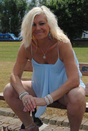 Hot mature Platinum Blonde flashes a hot panty upskirt on a park bench on nudesceleb.com