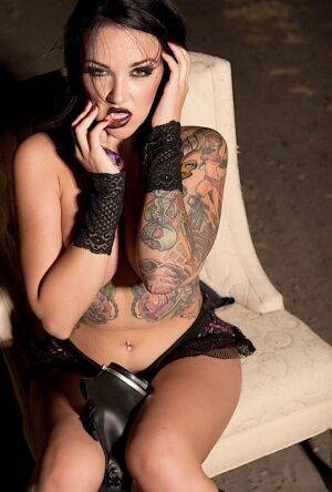 Tattooed girl Emily Parker takes off a gas mask and black bra outside at night on nudesceleb.com