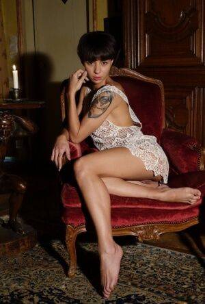 Solo model with short brunette hair exposes her hard body on a retro chair on nudesceleb.com