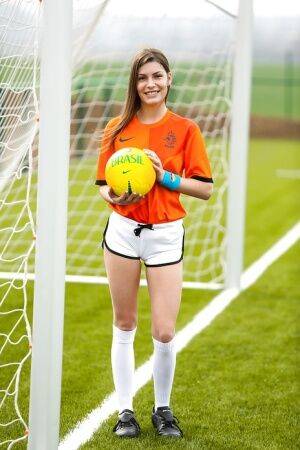 Lilly P is undressing her soccer uniform while on the field with a ball on nudesceleb.com