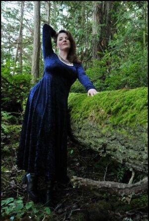 Mature woman Tasty Trixie heads into the woods to flash in a long velvet dress on nudesceleb.com