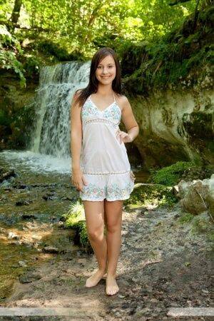 Solo girl Rosalin E removes lingerie to model naked in front of a waterfall on nudesceleb.com