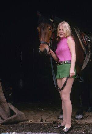 Blonde female reveals thigh and ass while mounting her horse in a short skirt on nudesceleb.com