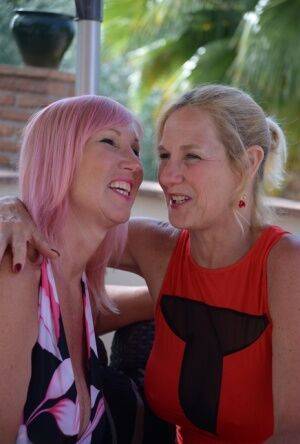 Middle-aged lesbians Melody & Molly MILF play with each others tits on a patio on nudesceleb.com