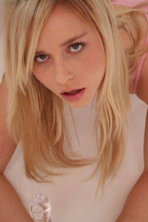 Hot blonde Kara Duhe on her knees shoving a glass dildo in her pretty face on nudesceleb.com