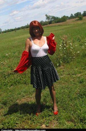 Older redhead Lauren models a retro girdle and nylons in a field on nudesceleb.com