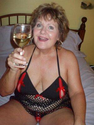 Older woman Busty Bliss licks her toy boy's dick over a glass of wine on nudesceleb.com