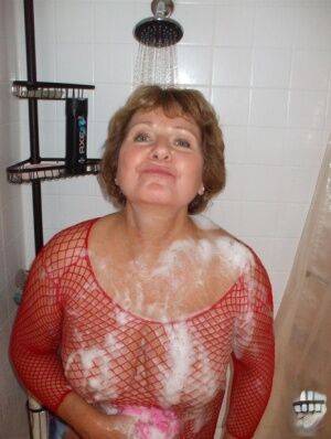 Older woman Busty Bliss soaps up her breasts before having her pussy licked on nudesceleb.com