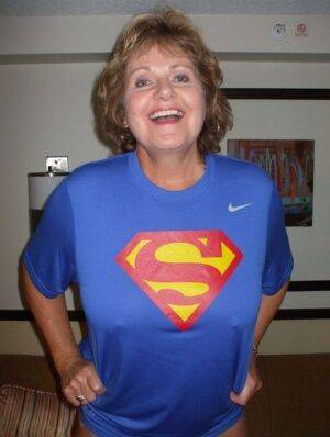Older amateur Busty Bliss looses her big tits from a Superman T-shirt on nudesceleb.com