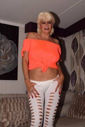 Mature amateur Dimonty models non nude in an off shoulder top and tight pants on nudesceleb.com