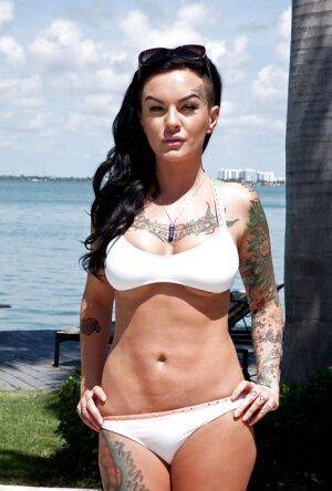 Tattooed whore Lolo Luscious exposing big hooters in swimming pool on nudesceleb.com