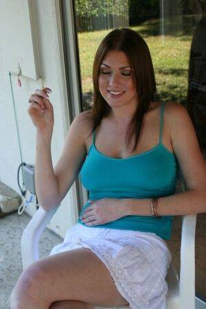 Barefoot chick Victoria Vonn smokes on the patio in a skirt and tank top on nudesceleb.com