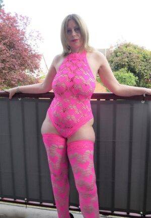 Older amateur Posh Sophia models pink lingerie before changing into a dress on nudesceleb.com