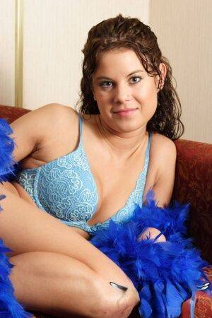 Brunette first timer Erin models non nude in elegant bra and blue feather boa on nudesceleb.com