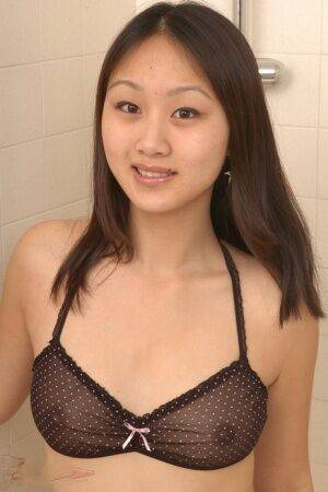 Asian amateur Evelyn slips off three piece lingerie to get naked in a shower on nudesceleb.com