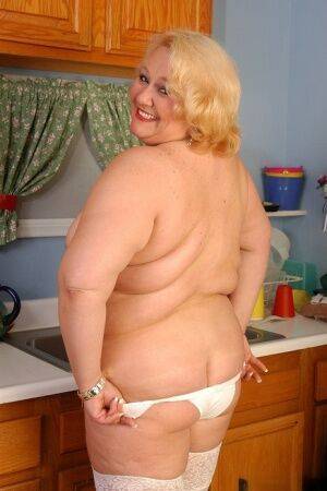 Older fat lady Britany models white stockings and underwear in the kitchen on nudesceleb.com