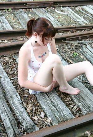 Redheaded girl Barbie A models a summer dress in bare feet on railway tracks on nudesceleb.com