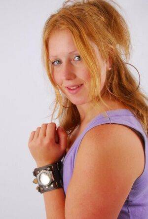 Natural redhead models a large cuff watch in a tank top and faded jeans on nudesceleb.com