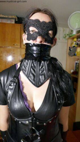 Brunette female models leather clothing while wearing a mask on nudesceleb.com