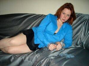 Redheaded girl gets naked on a sofa while sporting a collar and chains on nudesceleb.com