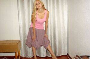 Clothed teen models in a skirt and tank top with curls put in her blonde hair on nudesceleb.com