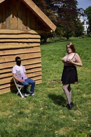 Natural redhead masturbates on a lawn before teasing a masked man on nudesceleb.com