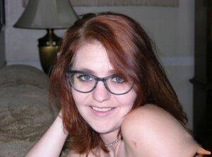 Young redhead with pierced nipples gets naked with her glasses on on nudesceleb.com