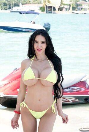Hot curvy Amy Anderssen flaunts enormously round big tits on her jet ski on nudesceleb.com