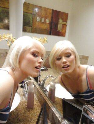 Young blonde hottie Ash Hollywood taking selfies in mirror while undressing on nudesceleb.com