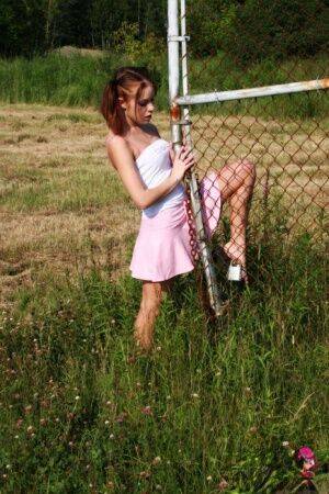 Young redhead Stunning Serena exposes her ass by a chain link fence on nudesceleb.com