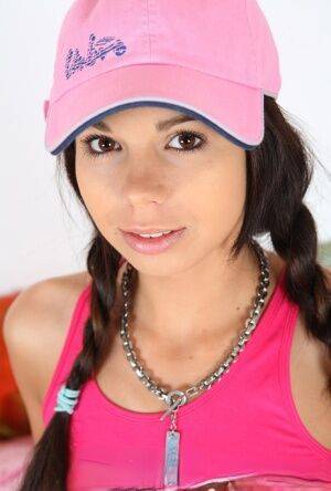 Cute teen Kiki 18 sports pigtails and a ballcap while having sex on a bed on nudesceleb.com