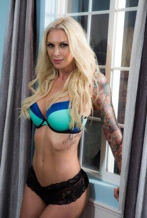 Tattooed MILF pornstar Brooke peels off bra & black lace panties to pose nude on nudesceleb.com