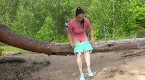 Brunette female Antonia Sainz squats by a fallen tree to take a piss on nudesceleb.com