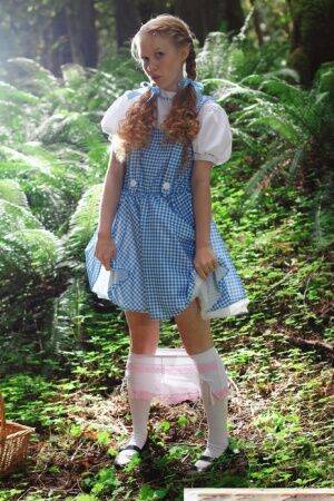 Charming redhead teen Dolly Little gets naked in white socks while in a forest on nudesceleb.com