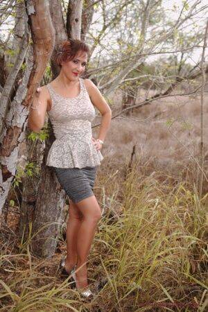 Mature pinup model Roni Ford kicks off pumps wearing retro lingerie in woods on nudesceleb.com