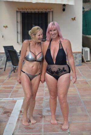 Mature BBW Melody and her girlfriend walk hand in hand by a pool in swimwear on nudesceleb.com