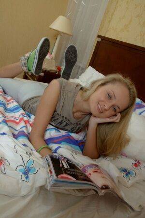 Cute blonde Rita reads a magazine in bed when a young man steps into the room on nudesceleb.com