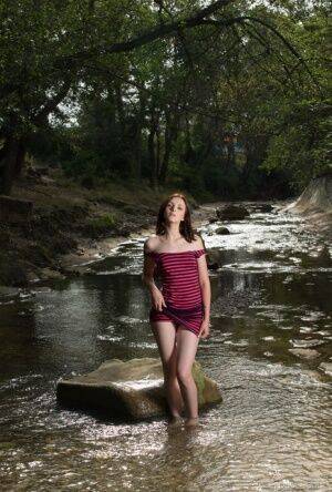 Teen solo girl Cordoba gets totally naked in a shallow stream on nudesceleb.com
