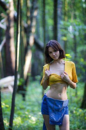 Skinny brunette Lara Masier gets completely naked in a mature forest on nudesceleb.com